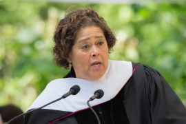 portrait of Anna Deveare Smith speaking at a podium in graduation robes